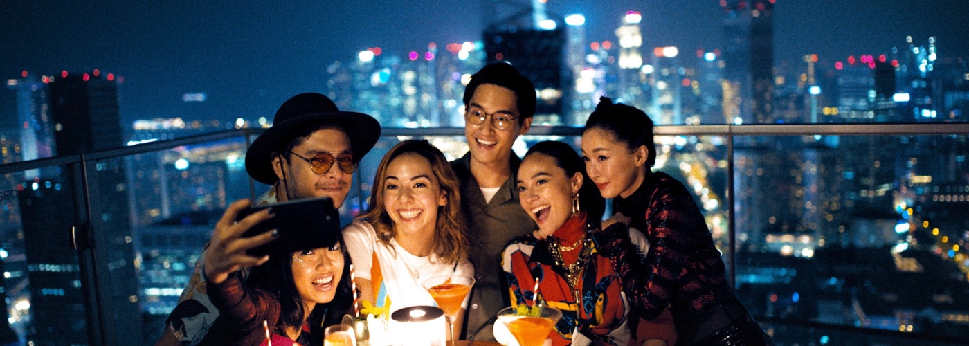 A group of friends taking a selfie together atop a bar